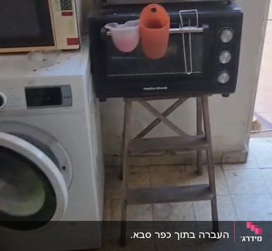 מכונת כביסה, מיקרוגל ותנור טוסטר על סולם עץ בחדר